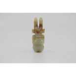 A Chinese pale celadon and russet jade amulet in the Neolithic style, Qing Dynasty, of semi-