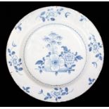 An English Delft polychrome blue and white charger decorated with central floral decoration, the