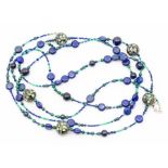 A long line bead necklace comprising various beads including lapis lazuli, green malacite, green