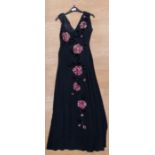 A black full length crepe v neck evening dress with a sequined pink and black floral decoration that