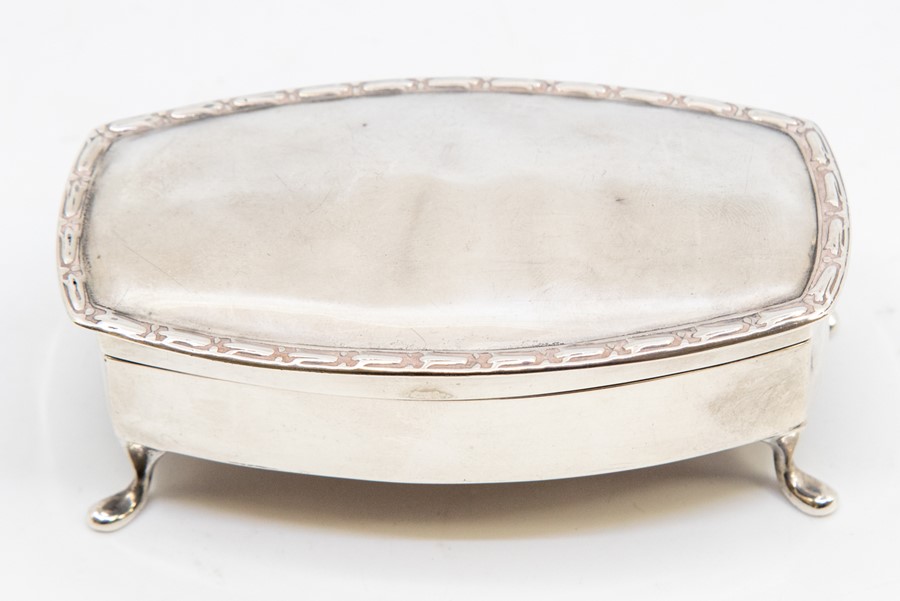 An early 20th century silver trinket box, rectangular shaped with tulip beaded rim, hinged lid to