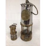 An early 20th Century miners lamp, brass and cast along with a miniature