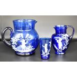 A collection of glass wares to include Mary Gregory blue glass style water jugs and glass