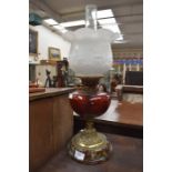 A Victorian ruby glass oil lamp with treacle glaze base and shade