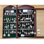 A collection of commemorative silver and silver plate items including teaspoons in collectors wooden