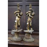 A pair of gilt table lamps with putti's holding basket of flowers, no shades