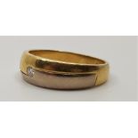 An 18ct. bi-colour gold and diamond ring, flush set single round cut diamond. (gross weight 6.0g)