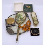 A collection of powder compacts, hair brushes and amber style necklace