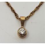 A precious yellow metal and diamond pendant, bezel set single round brilliant cut diamond (diamond