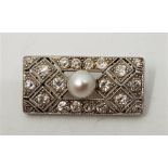An Art Deco precious white metal, diamond and pearl set brooch, of pierced geometric design, set