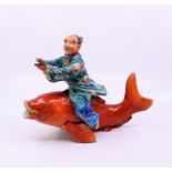 A Japanese pottery fisherman straddling a  carp