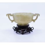 A Chinese Qing dynasty jade libation cup with later wooden stand