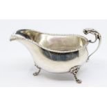 A Georgian style silver helmet shaped sauce boat, feathered edge border above plain body engraved