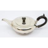 An Edwardian plain silver squab teapot, ebony C-scroll handle and urn shaped finial, by William