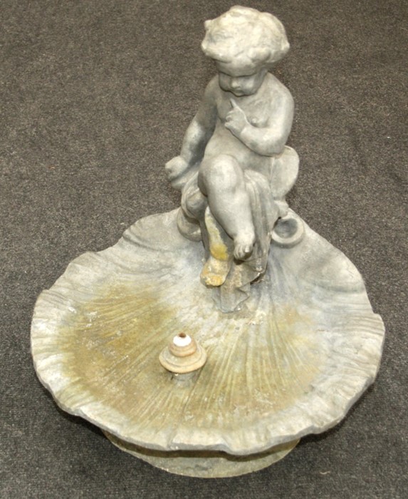 A 20th century cast lead garden water feature, modelled with putto seated upon open scallop shell,