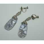 A pair of carved lilac jade drop earrings with white metal filigree tops, on screw fittings,
