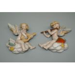 A pair of early 20th century probably Austrian terracotta wall ornaments, each modelled as a putto