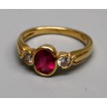 A pink tourmaline ring, the oval stone set between two diamonds on an 18ct gold shank, size O, 5gm