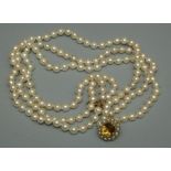 A three strand cultured pearl necklace, comprising round cream pearls with pink overtone, each