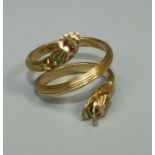 A double headed unmarked yellow metal serpent ring, the eyes and head set with emerald and ruby,