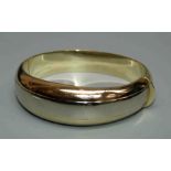 A three colour gold bangle, the snap clasp stamped .375. 30gm