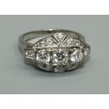 A diamond and unmarked white metal cluster ring, comprising three graduated round brilliant cut