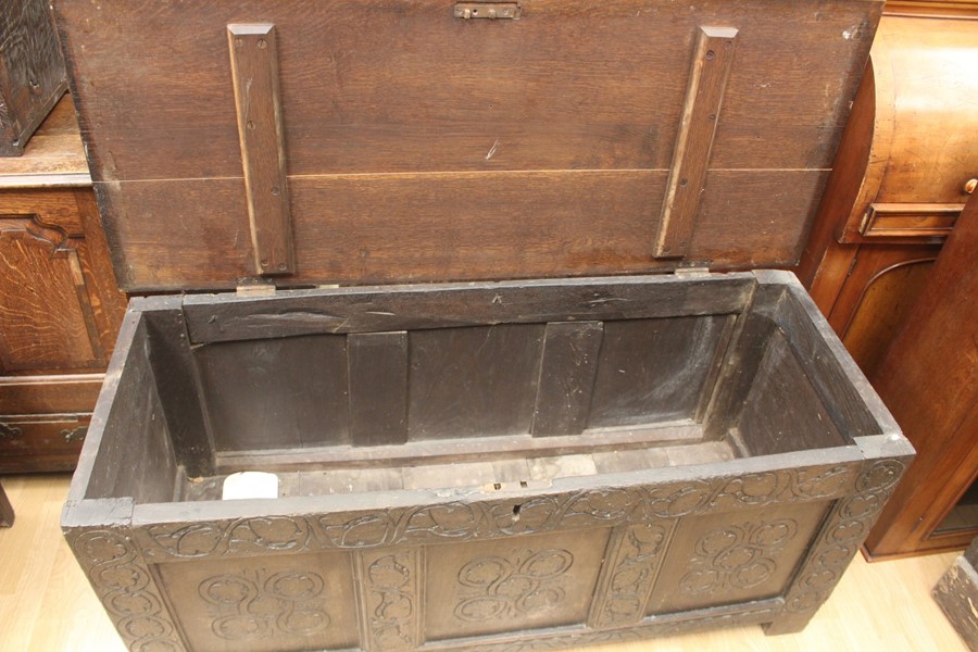 An early 18th Century joined oak coffer, having a three panelled front, carved plank top, 63cm high, - Image 3 of 4