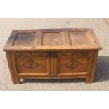 An early 18th Century joined oak chest, panelled lid, having a lunette carved frieze and lozenge