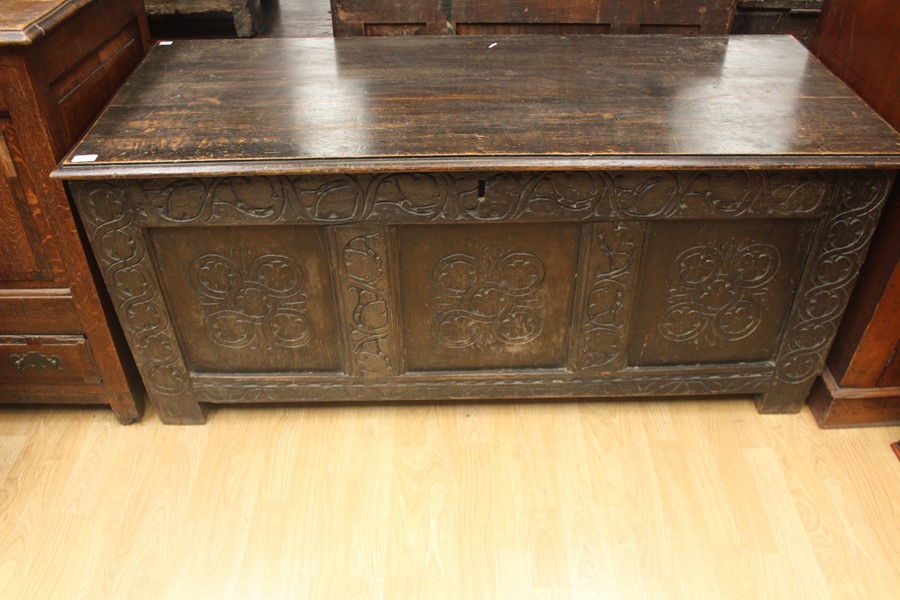 An early 18th Century joined oak coffer, having a three panelled front, carved plank top, 63cm high,