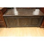 An early 18th Century joined oak coffer, having a three panelled front, carved plank top, 63cm high,
