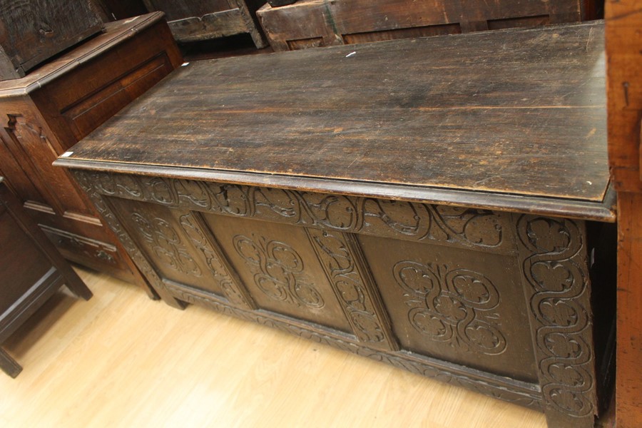 An early 18th Century joined oak coffer, having a three panelled front, carved plank top, 63cm high, - Image 2 of 4