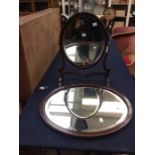 An Edwardian style stained wood oval shaped dressing table mirror and an oval wall mirror (2)