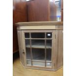 An early 20th Century beech and pine glazed hanging corner cupboard, 57cm high, 63cm wide