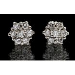 A pair of diamond and platinum flower cluster earrings, set with round brilliant cut diamonds with a