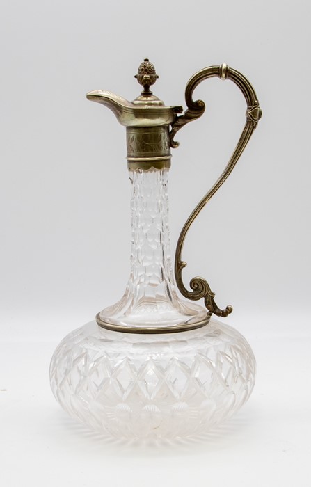 An Edwardian cut glass and silver plate mounted claret jug, bulbous shape with scrolling shape,