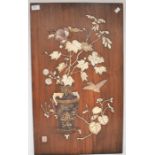 A Japanese panel inset with raised decoration depicting vase of flowers on table with bird,