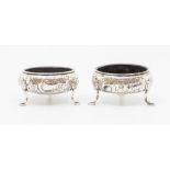A pair of George III silver circular salts, the bodies chased with floral decoration and vacant