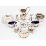 A collection of silverware comprising condiments, including a pair of salt cellars, mustard pots,