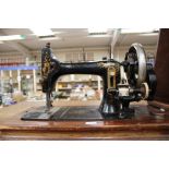 An early 20th century hand powered sewing machine, serial number 307427, fitted in the original