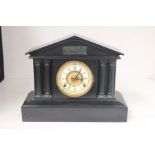 Late 19th century French black slate mantle clock colosseum design with Roman numerals.