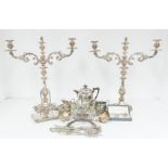 Two large silver plate candle sticks along with a collection of silver plat items including tea