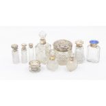 A collection of early 20th Century silver topped scent and toilet cut glass bottles, six with silver