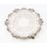 A Victorian shaped circular salver, scroll and foliate wavy raised border above three foliate scroll