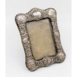 An Edwardian ornate silver photograph frame with embossed decoration featuring Reynolds angels' size