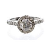 A diamond halo 18ct white gold solitaire ring, comprising a brilliant cut diamond weighing approx