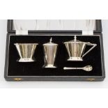 A Modernist style silver three piece condiment set, conical shaped plain bodies, the covers with urn