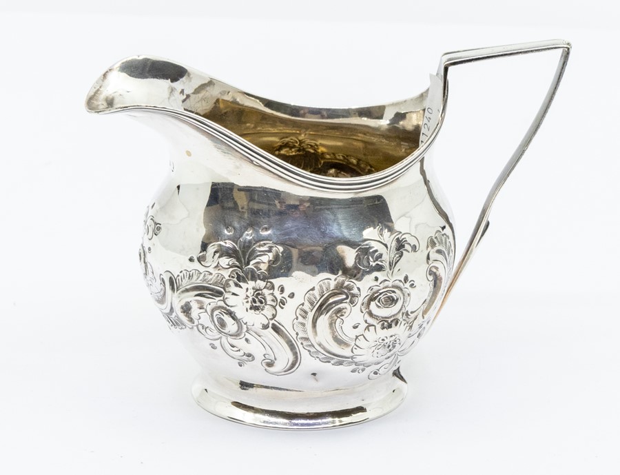 A George III silver helmet shaped cream jug, later chased with floral decoration, London, 1805, 2.93