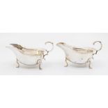 A pair of Georgian style silver sauceboats, wavy borders on three club feet, c-scroll handles, by