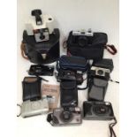 A collection of assorted cameras, including Roniflex, Halina camera, Polaroid, plus many more.