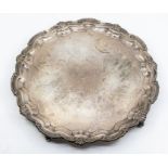 An Edwardian silver plain large salver, raised scroll and scallop border on four scroll feet, by